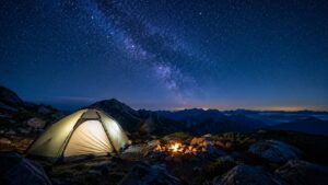 夜の山中でテントにヘッドランプが光るキャンプサイト